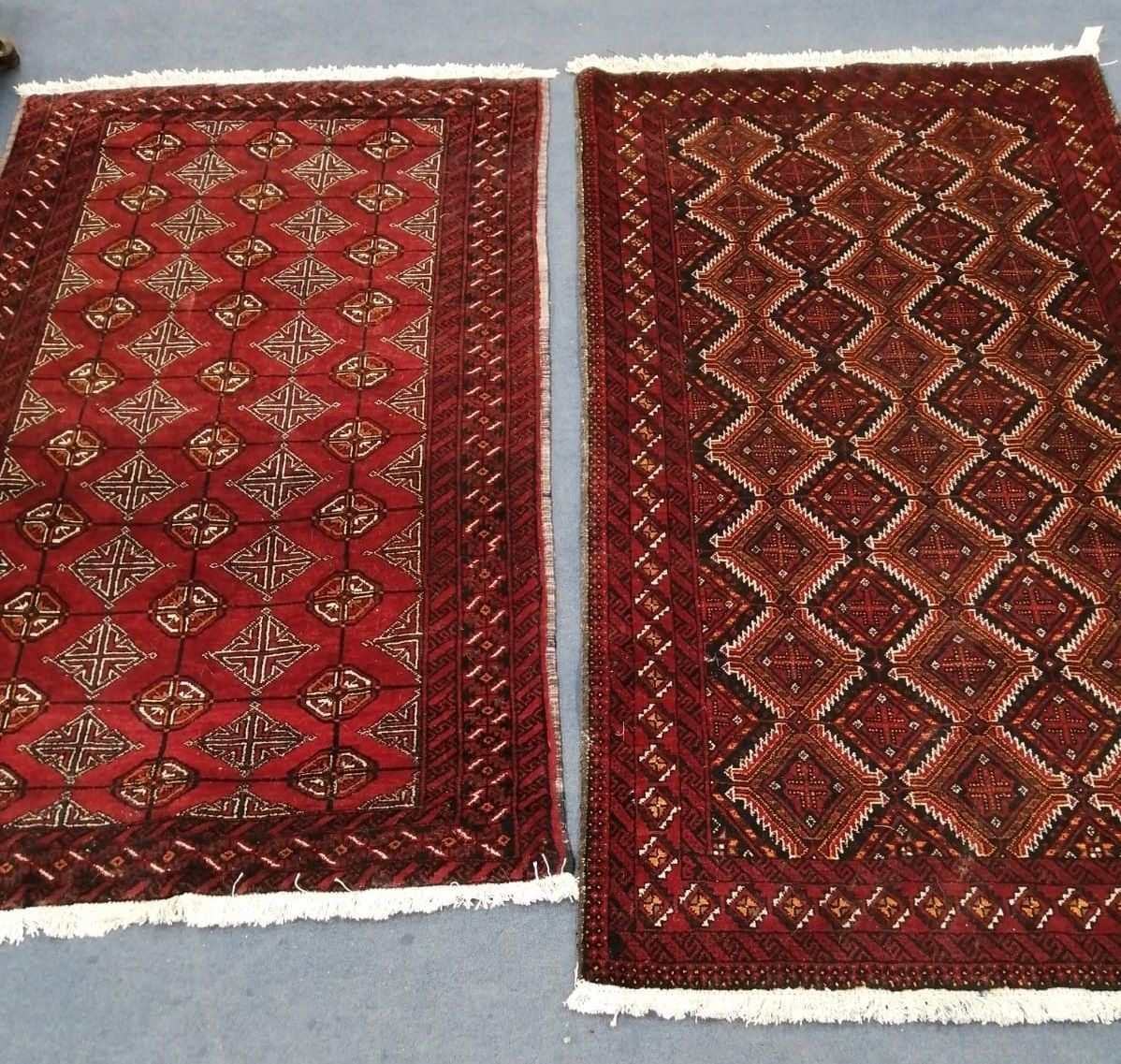 A near pair of Belouch burgundy ground rugs, larger 200 x 110cm